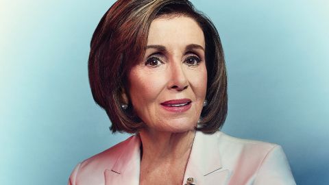 Nancy Pelosi in a pink coat poses a picture.